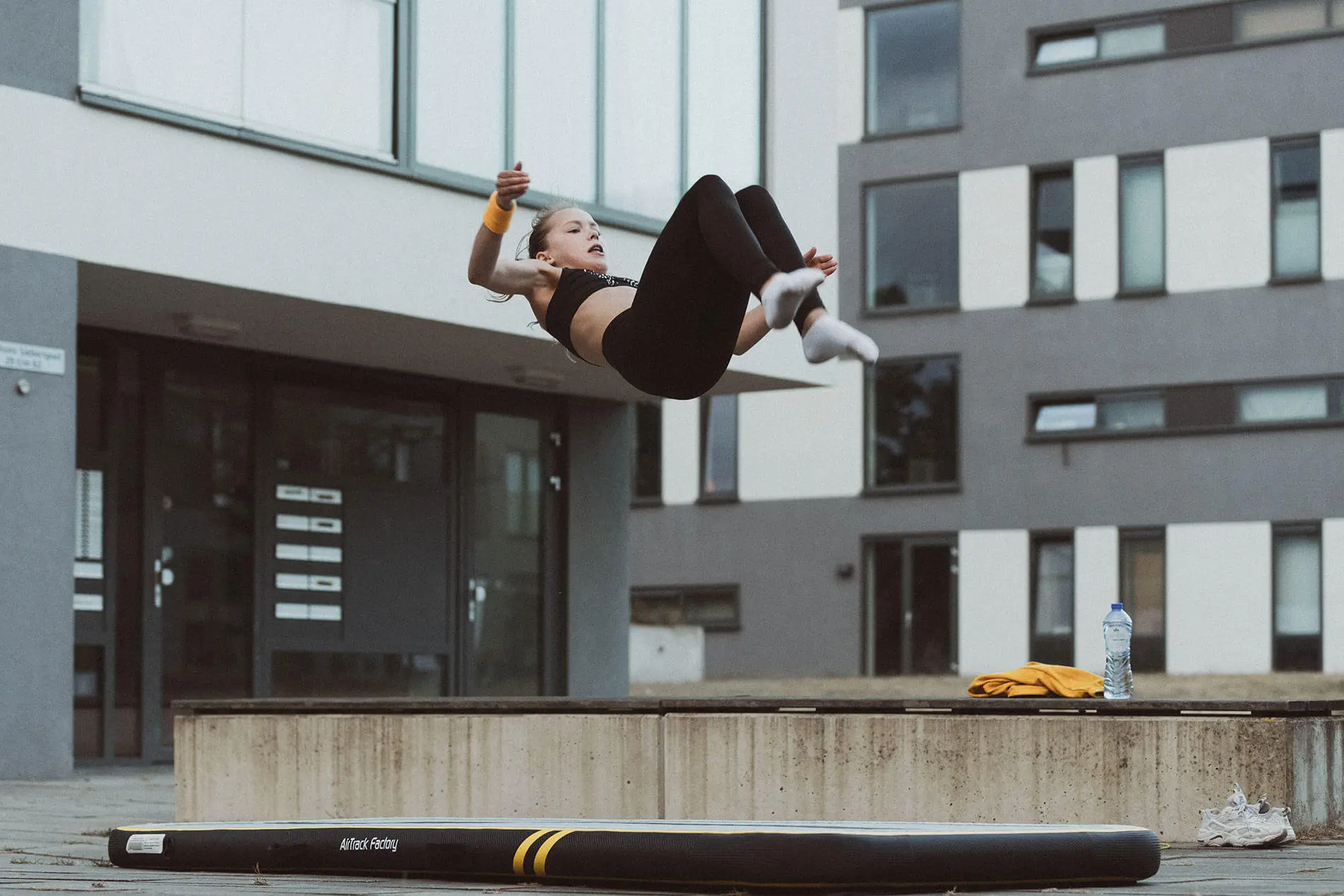 Gymnast backflip outside on inflatable tumbling floor