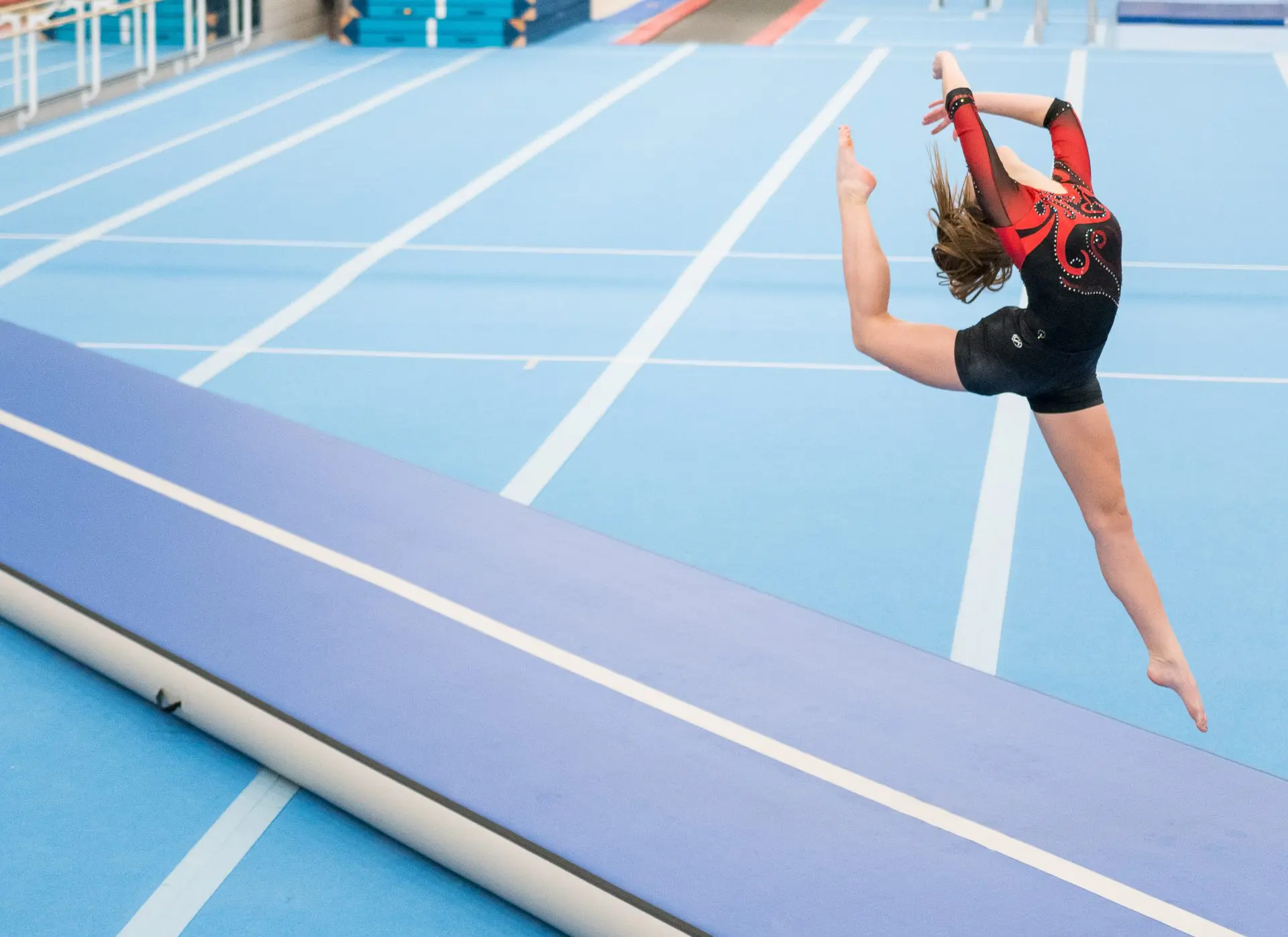 gymnast leaping on blue airtrack p3